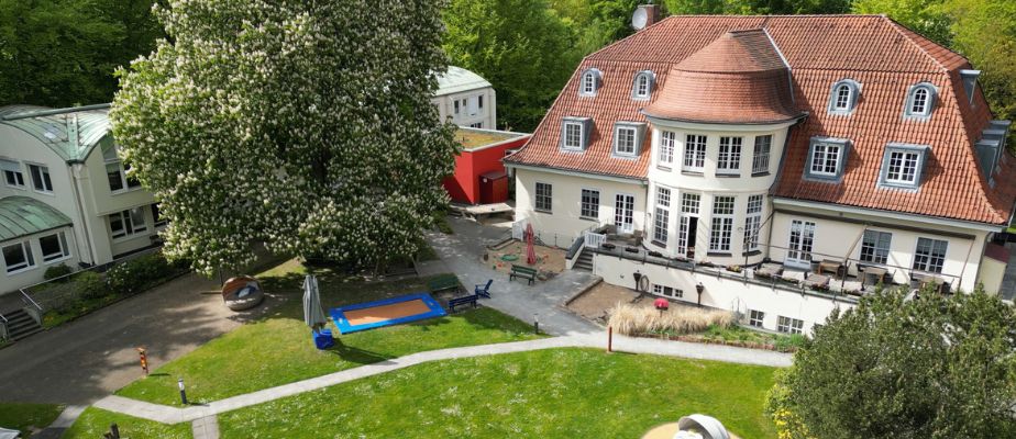 Eine Luftaufnahme vom Neuen Kupferhof. Man sieht das alte Herrenhaus, den etwas jüngeren Anbau und den Garten.
