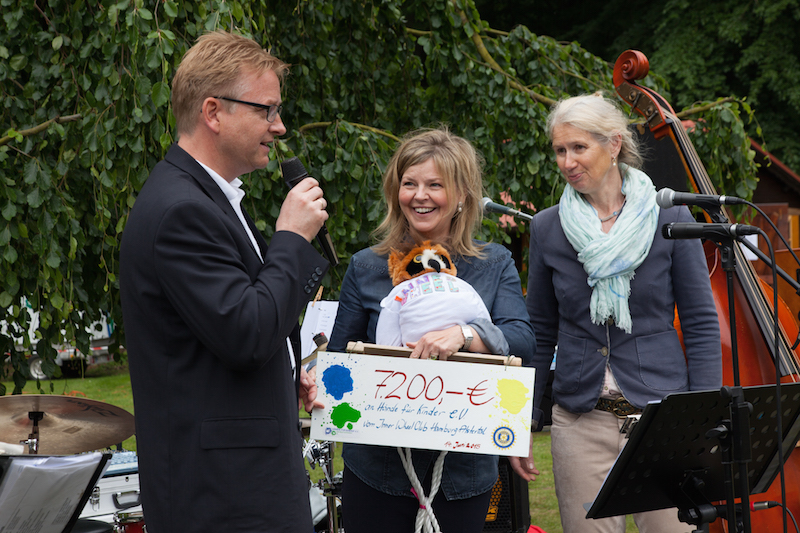 Personen bei einer Veranstaltung, die einen Scheck über 7200 Euro präsentieren.