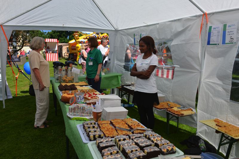 Ein Tisch mit einer Auswahl an Backwaren, darunter Kuchen und Gebäck, auf einem Fest.