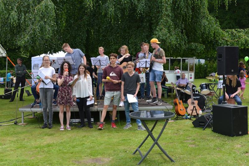 Gruppe von Jugendlichen auf einer Bühne während einer Musikaufführung bei einem Sommerfest.