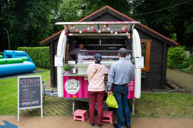 Zwei Personen, die vor einem Eiswagen stehen.