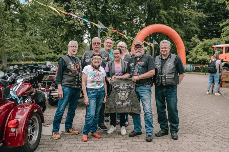 Eine Gruppe von acht Motorradfahrer:innen posiert für ein Foto.
