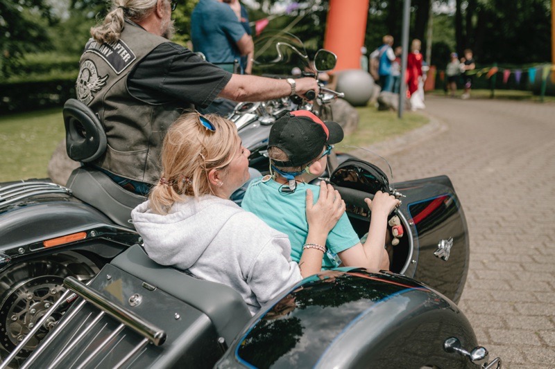 Eine Frau sitzt mit einem Kind im Seitenwagen eines Motorrads.