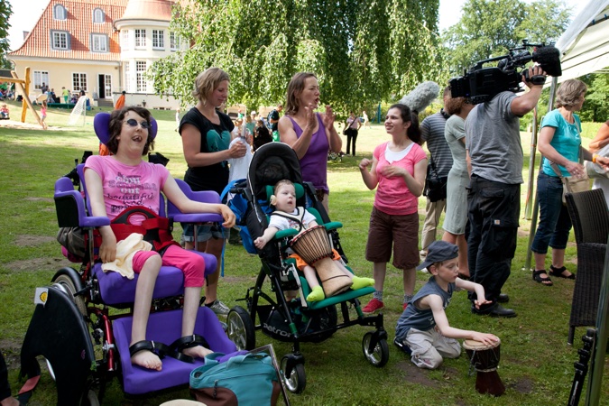 Eine Gruppe von Menschen mit Behinderungen, die an einer Veranstaltung teilnehmen, einige sitzen in Rollstühlen.