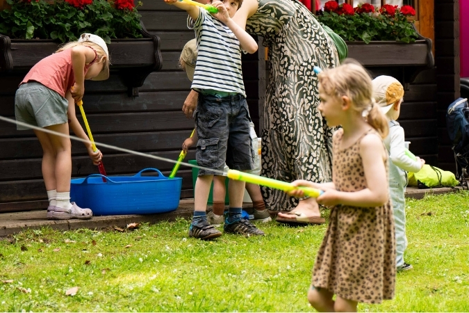 Mehrere Kinder spielen mit Wasserpistolen.