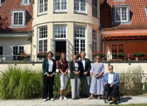 Vor dem Neuen Kupferhof stehen sechs Personen. Von links nach rechts sind Gesche Emme, Viola Hellwege, Funda Gür, Steffen Schumann und Hans Nee zu sehen.